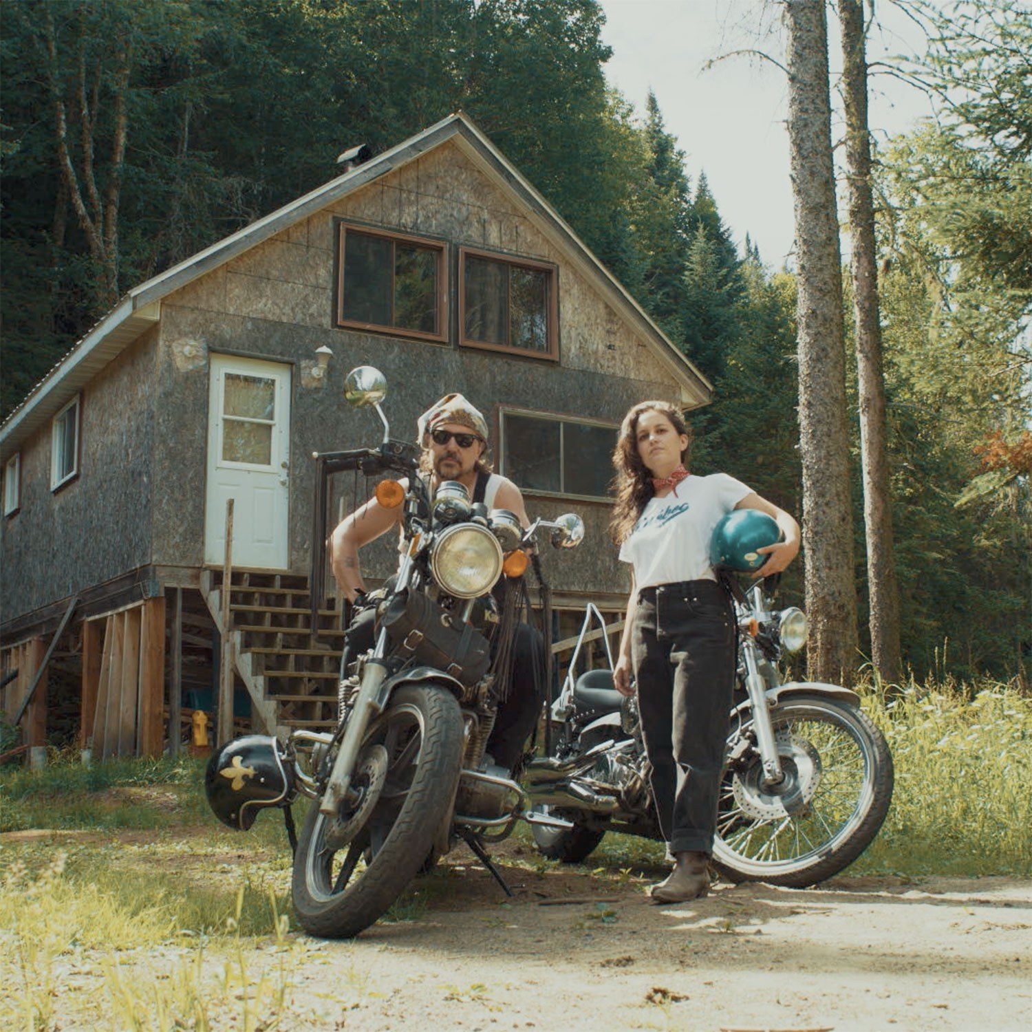 Le duo Ellemetue devant un chalet avec leur motos
